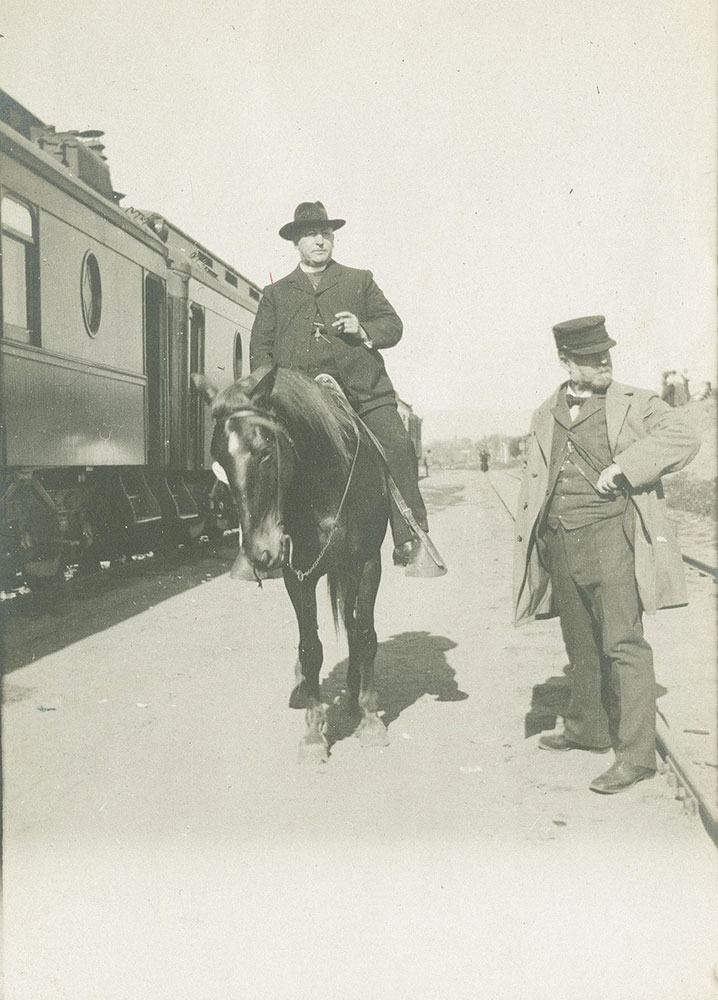 Large man on horse next to train