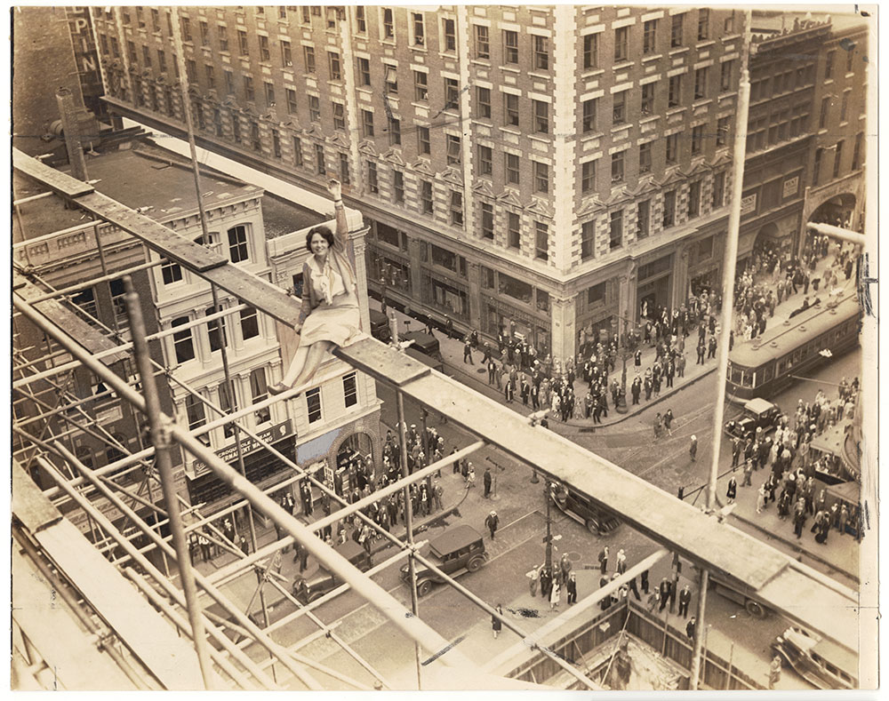 Vivian Shirley sitting on scaffolding atop the Federal Reserve Bank (under construction)